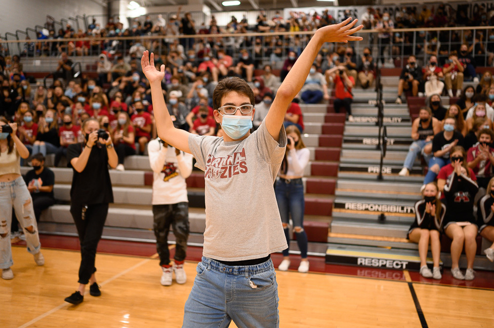 A student celebrates Homecoming in the gym.