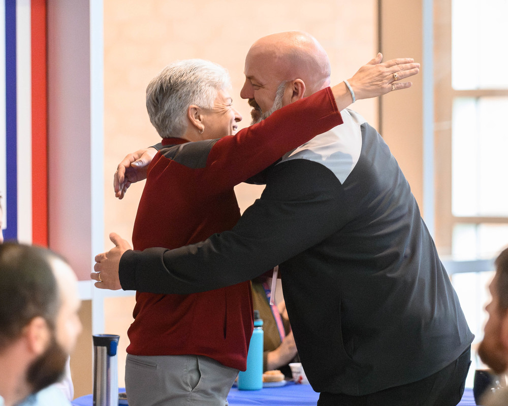 ACHS principal Michael Berrie and retiring dean Pat McGuigan hug at the  annual staff recognition tea